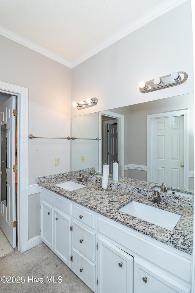 bathroom with a sink, ornamental molding, and double vanity