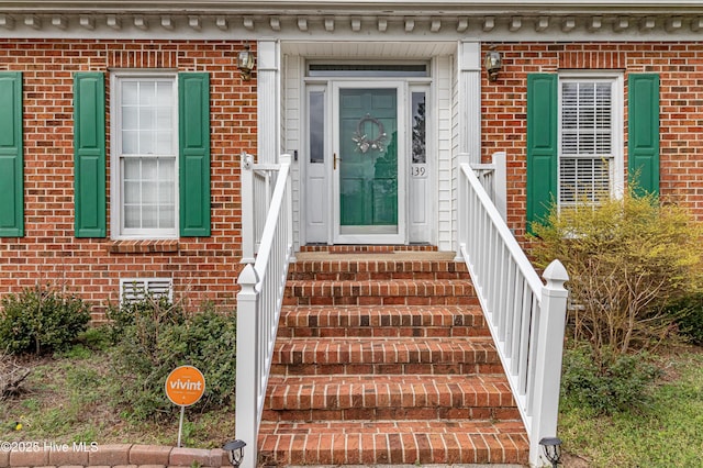 entrance to property featuring brick siding