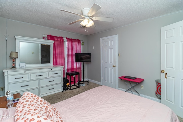 carpeted bedroom with a textured ceiling, baseboards, and a ceiling fan