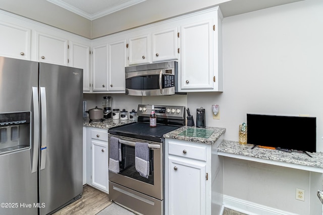 kitchen with light stone counters, appliances with stainless steel finishes, ornamental molding, and white cabinetry