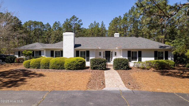 ranch-style house featuring a chimney