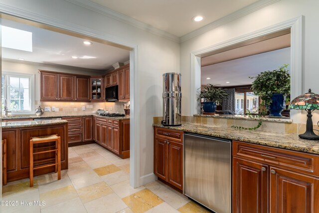 kitchen with light stone countertops, black microwave, decorative backsplash, and glass insert cabinets