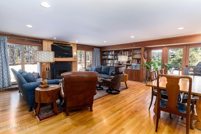 living room featuring light wood-type flooring, french doors, a fireplace, and recessed lighting