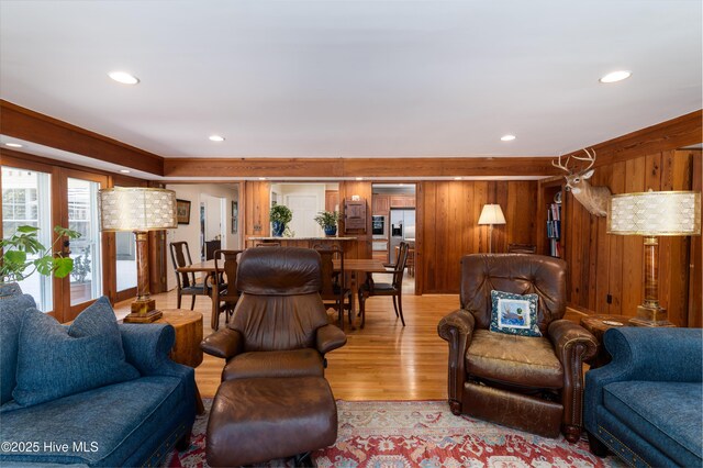 living area featuring recessed lighting, wooden walls, and light wood-style flooring