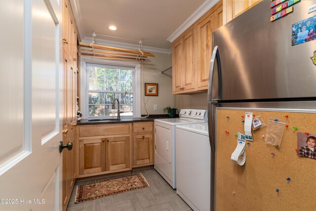 laundry area with washer and dryer, ornamental molding, a sink, and cabinet space