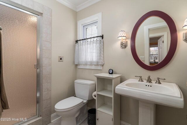 bathroom with a shower stall, a wealth of natural light, toilet, and ornamental molding