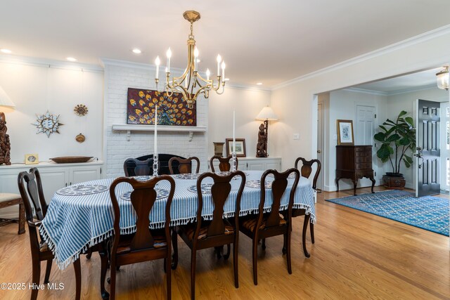 dining space featuring light wood finished floors, an inviting chandelier, and crown molding