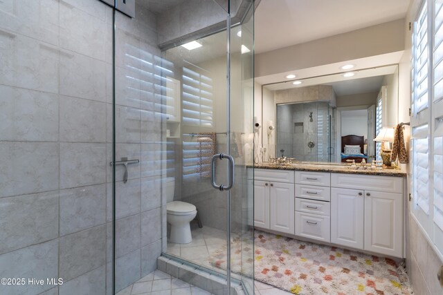 bathroom featuring tile walls, tile patterned floors, vanity, and a stall shower