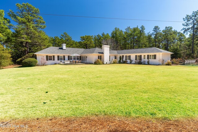view of front of property featuring a chimney and a front lawn