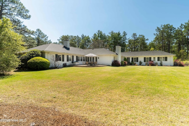 single story home with a chimney and a front yard