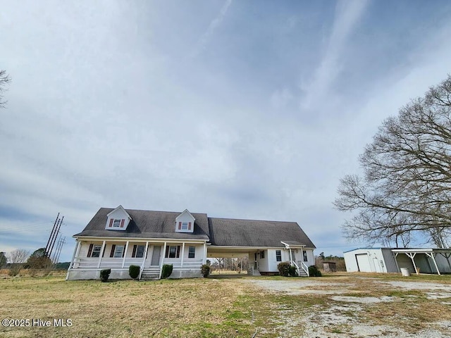105 Hollowell Rd, Aulander, NC 27805 - cape cod house featuring an outbuilding, covered porch, a detached garage, and a front lawn