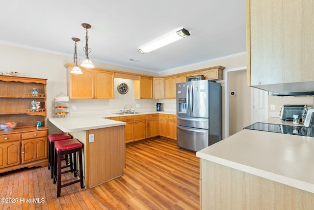 6 White Ln, Oak Island, NC 28465 - kitchen featuring light wood-type flooring, stainless steel refrigerator with ice dispenser, crown molding, and a sink
