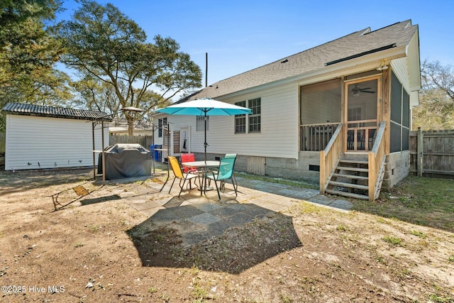 6 White Ln, Oak Island, NC 28465 - rear view of property featuring a sunroom, roof with shingles, fence, and a patio area