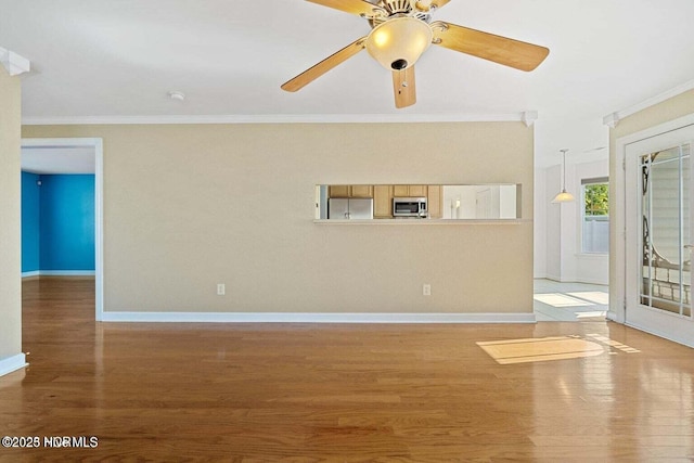 empty room with ceiling fan, baseboards, light wood-style floors, and ornamental molding