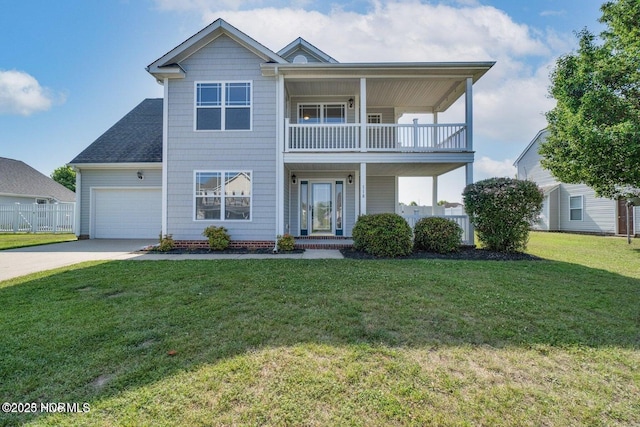 view of front of property featuring driveway, fence, a front yard, an attached garage, and a balcony