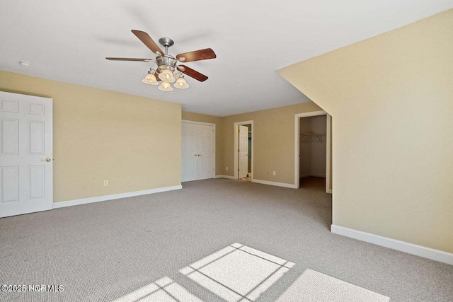 empty room featuring baseboards, carpet floors, and ceiling fan