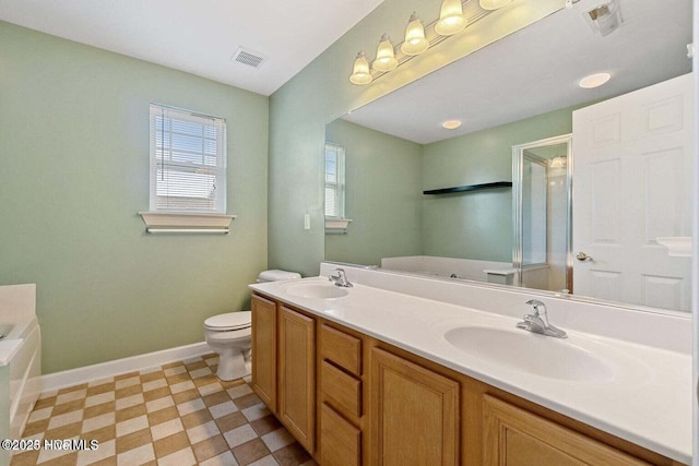 bathroom featuring visible vents, baseboards, a garden tub, and a sink
