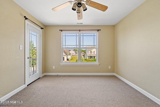 carpeted empty room featuring plenty of natural light, baseboards, and ceiling fan