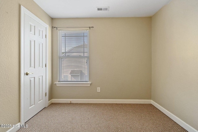 empty room with light colored carpet, visible vents, and baseboards