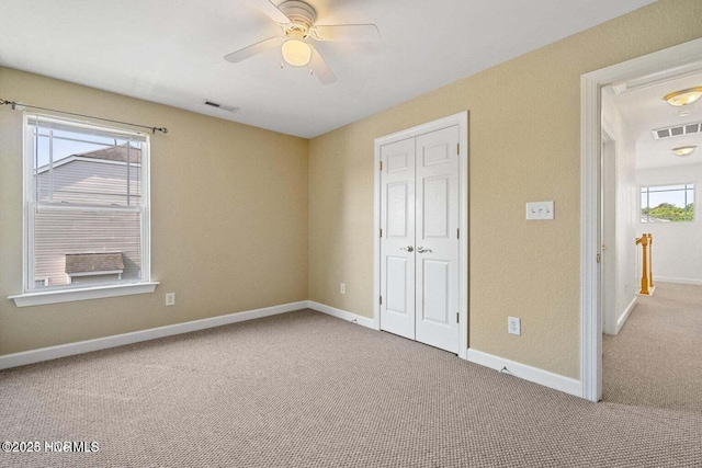 unfurnished bedroom featuring carpet flooring, baseboards, and visible vents