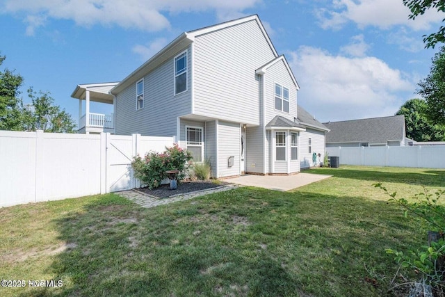 back of property featuring a gate, cooling unit, a lawn, and a fenced backyard