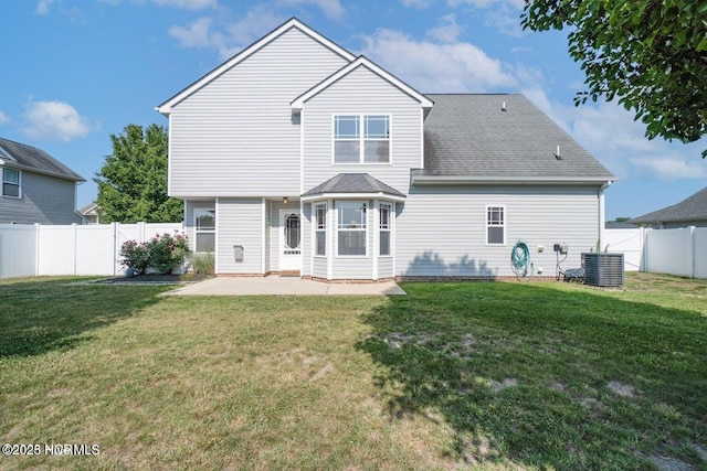 rear view of house with a patio area, a yard, central AC unit, and a fenced backyard
