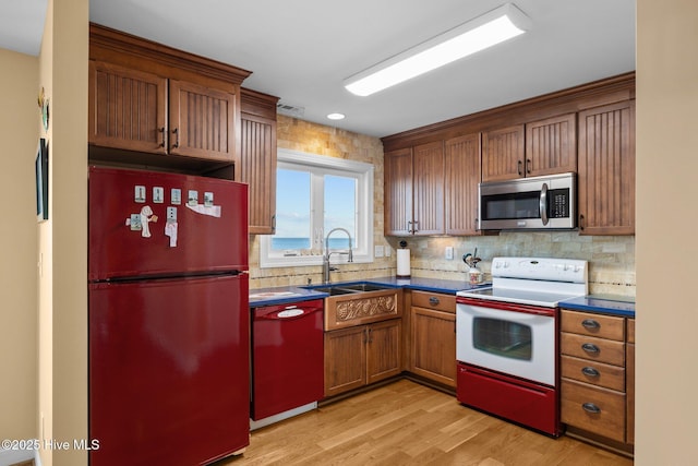 kitchen with dishwasher, stainless steel microwave, dark countertops, white range with electric cooktop, and freestanding refrigerator