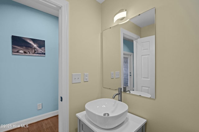 bathroom featuring vanity, baseboards, and wood finished floors