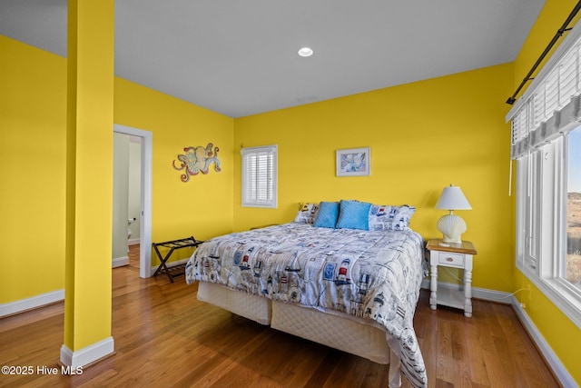 bedroom with baseboards, wood finished floors, and recessed lighting