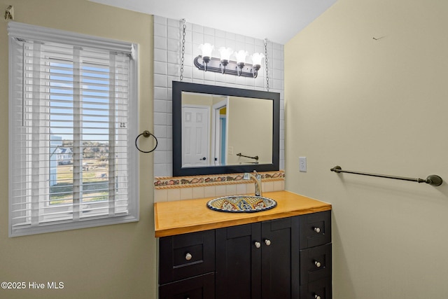 bathroom featuring vanity and backsplash