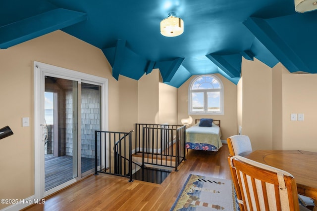 bedroom with baseboards, vaulted ceiling, and wood finished floors