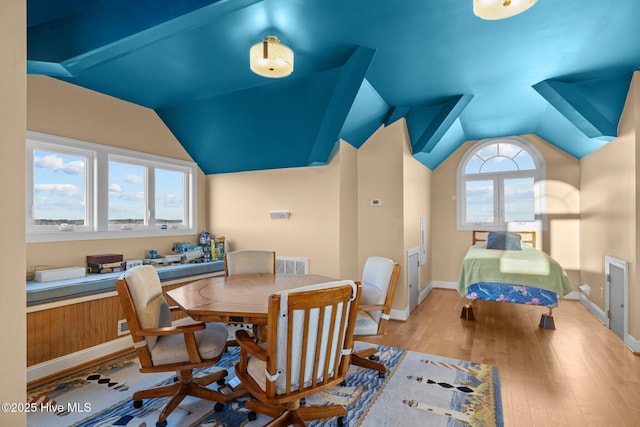dining room with baseboards, light wood-style floors, vaulted ceiling, and visible vents