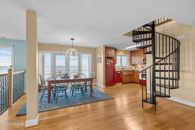 dining space with baseboards, stairs, a wealth of natural light, and light wood-style flooring