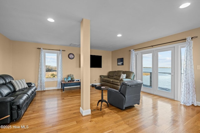 living area featuring visible vents, light wood-style floors, and recessed lighting