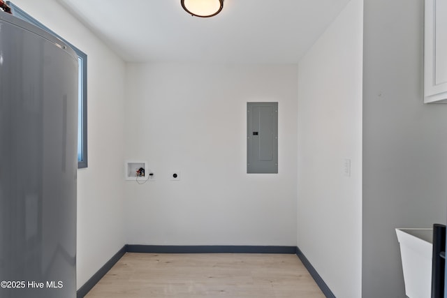 clothes washing area with electric panel, light wood-style flooring, baseboards, laundry area, and washer hookup