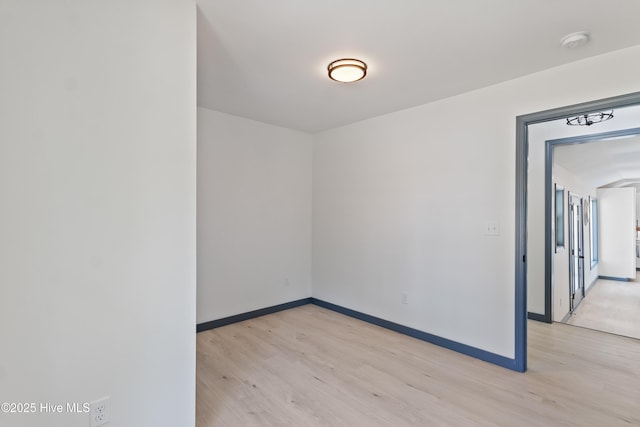 empty room with light wood finished floors and baseboards