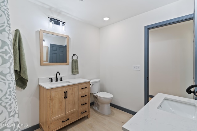 full bath featuring baseboards, wood finished floors, vanity, and toilet