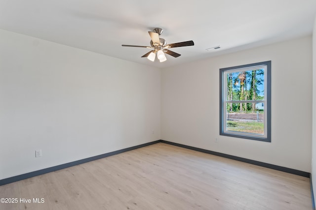 unfurnished room featuring baseboards, a ceiling fan, visible vents, and light wood-style floors