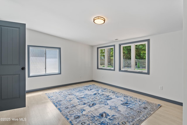 empty room with light wood-type flooring and baseboards