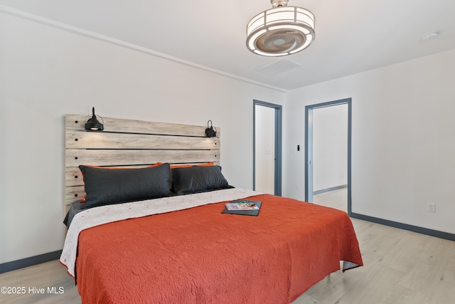 bedroom with light wood-type flooring and baseboards
