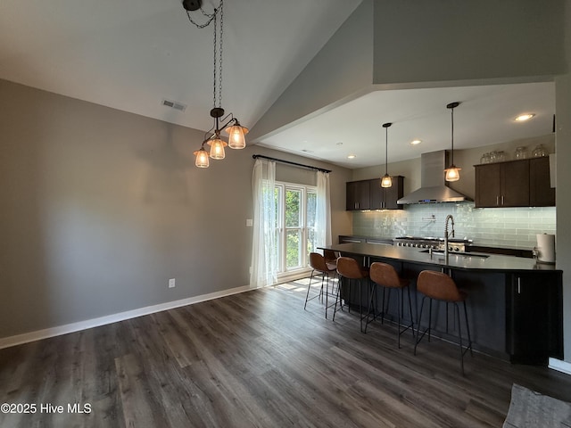 1123 Mill Run Rd, Sneads Ferry, NC 28460 - kitchen featuring visible vents, a breakfast bar, dark countertops, wall chimney exhaust hood, and a sink
