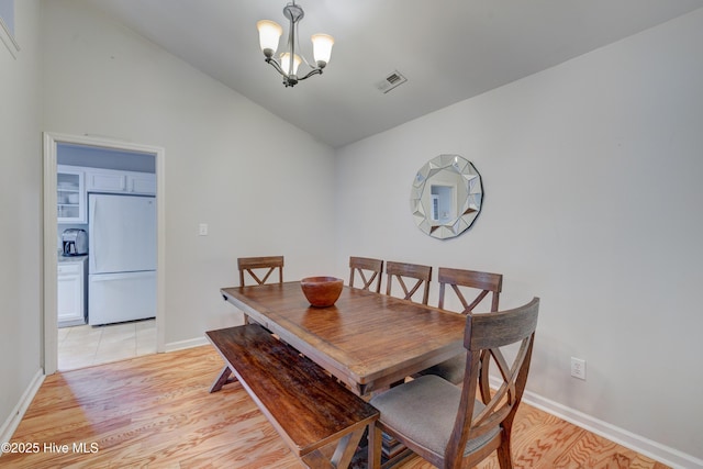 1414 Kellum Ct, Wilmington, NC 28412 - dining space featuring a chandelier, light wood-style flooring, lofted ceiling, and baseboards
