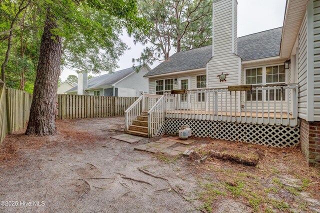 1414 Kellum Ct, Wilmington, NC 28412 - back of property featuring roof with shingles, a fenced backyard, a chimney, and a deck