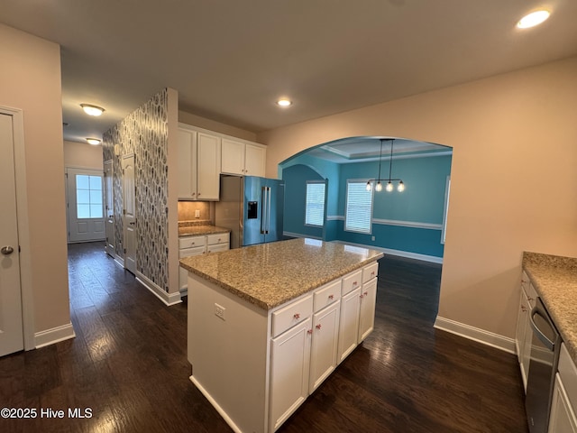 427 Wolfe Ln, Hubert, NC 28539 - kitchen featuring stainless steel appliances, arched walkways, dark wood finished floors, white cabinets, and a center island