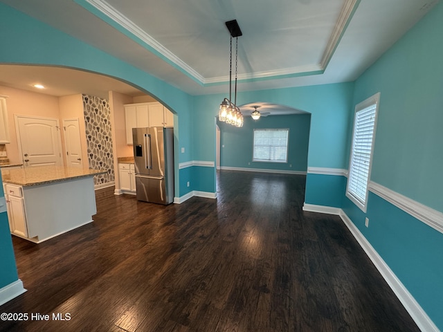 427 Wolfe Ln, Hubert, NC 28539 - unfurnished dining area featuring a tray ceiling, a ceiling fan, arched walkways, dark wood finished floors, and ornamental molding