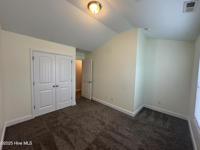 427 Wolfe Ln, Hubert, NC 28539 - unfurnished bedroom featuring vaulted ceiling, dark carpet, and a closet