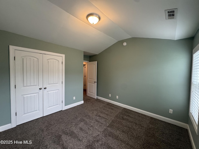 427 Wolfe Ln, Hubert, NC 28539 - unfurnished bedroom with dark carpet, vaulted ceiling, and a closet