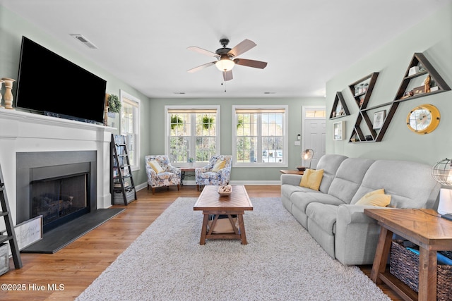 214 Green Trees Dr, New Bern, NC 28560 - living area with ceiling fan, a fireplace with raised hearth, wood finished floors, and visible vents