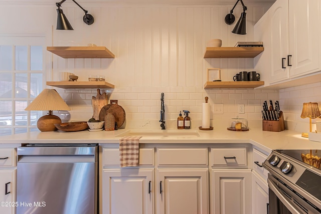 kitchen featuring open shelves, light countertops, white cabinets, stainless steel appliances, and a sink