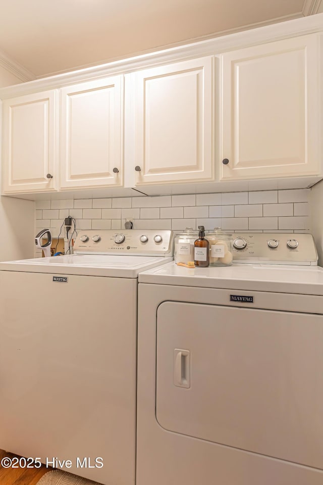 laundry area featuring washing machine and clothes dryer and cabinet space